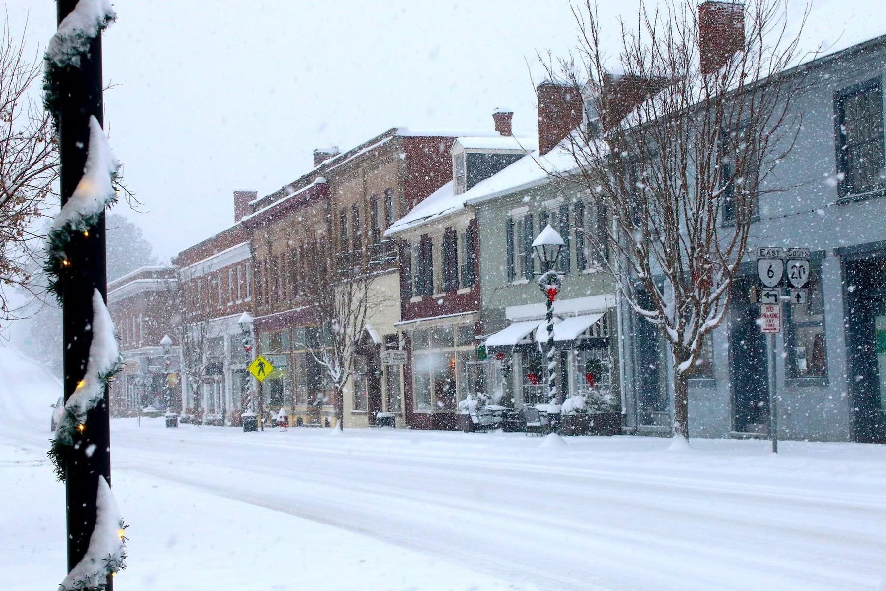 Snow-covered storefronts along historic Valley Street, with a wreath on a lamppost